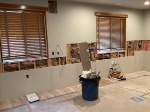 Base walls after cabinets have been removed. Some necessary openings are made in the drywall to provide access to plumbing. 
